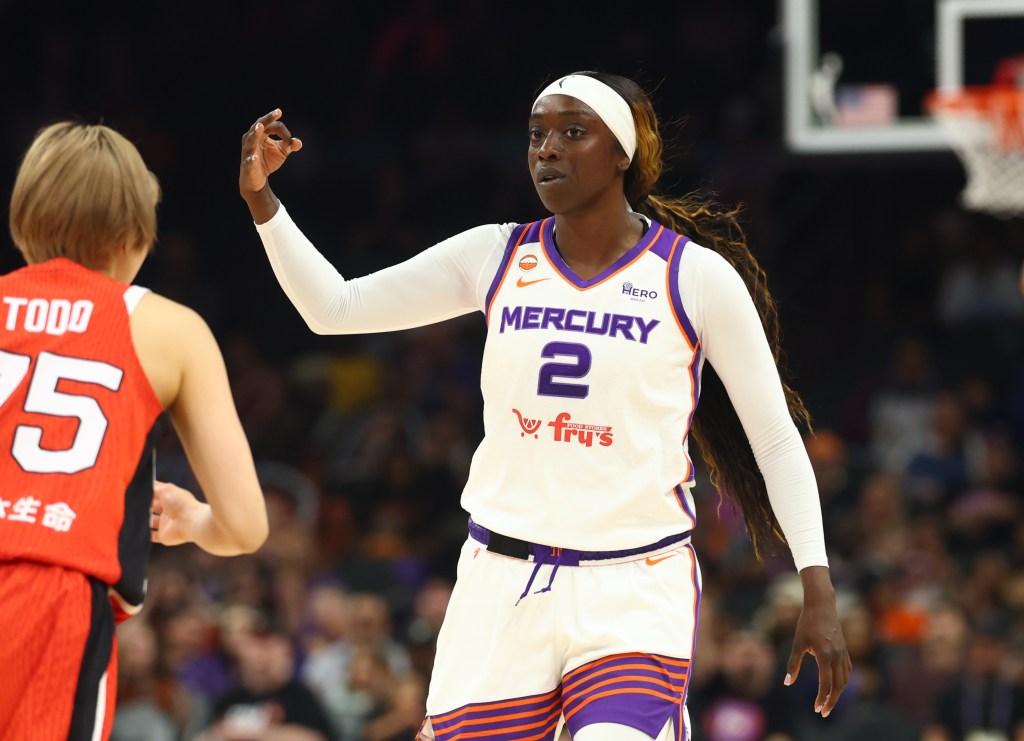 Kahleah Copper in a white Phoenix Mercury uniform with the number 2 gestures during a game. Another player, wearing a red jersey with number 75, faces her.