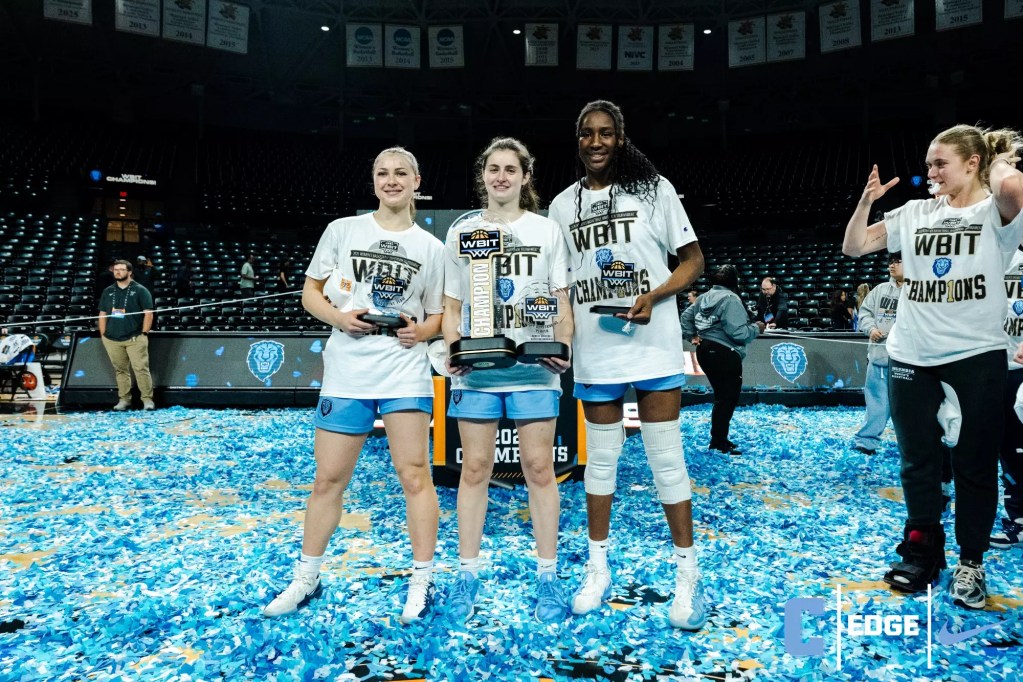 Columbia players Mia Broom, Riley Weiss and Susie Rafiu smile for a photo while holding trophies for winning the WBIT and making the All-Tournament team. Light blue confetti coats the court all around them.