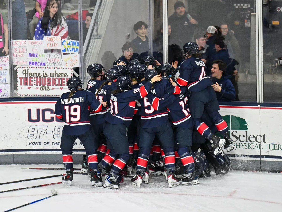 UConn celebrates along the glass in a huge pileup