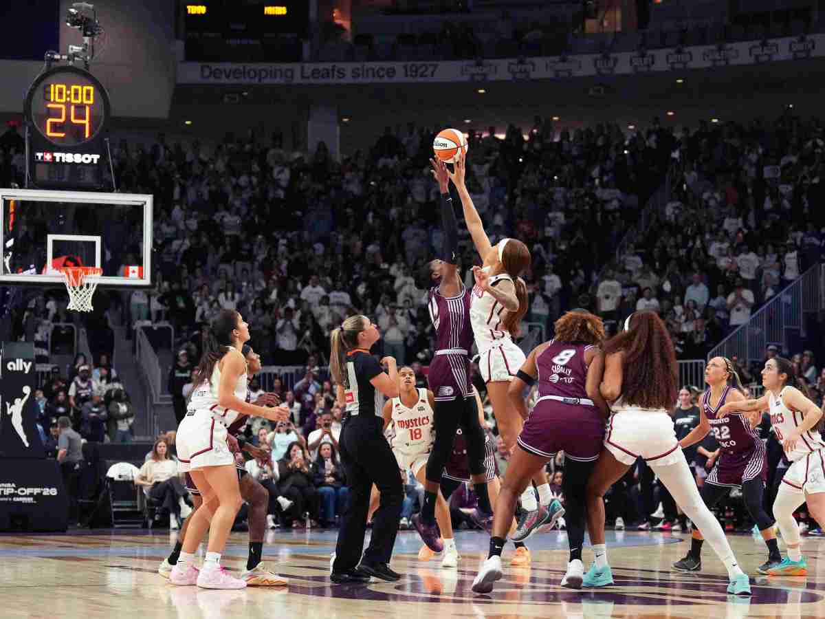 Washington Mystics center Shakira Austin and Toronto Tempo center Temi Fagbenle jump for the opening tip at center court. Both have one arm fully extended, reaching for the ball.