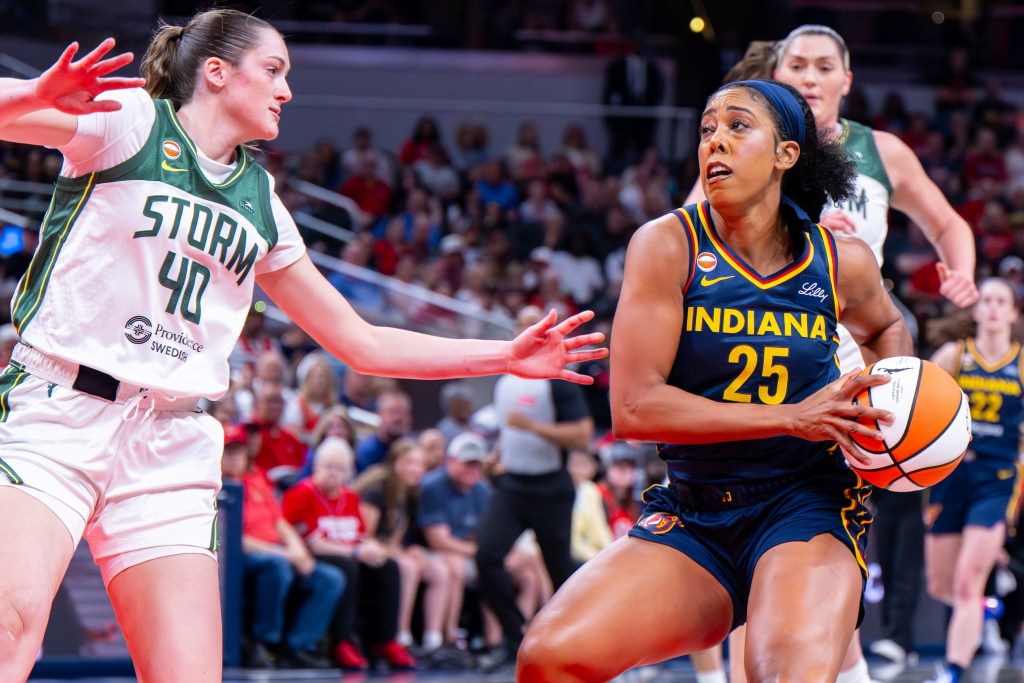Indiana Fever forward Monique Billings (25) is stopped en route to the basket by Seattle Storm forward Grace Vanslooten (40)