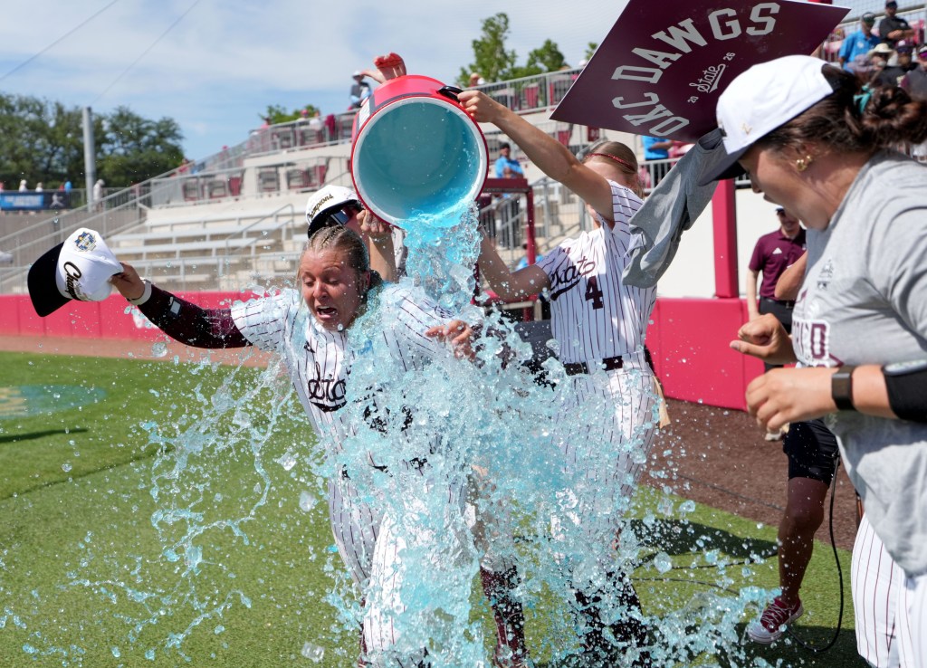 Mississippi State pitcher Delainey Everett has blue Gatorade dumped on her.
