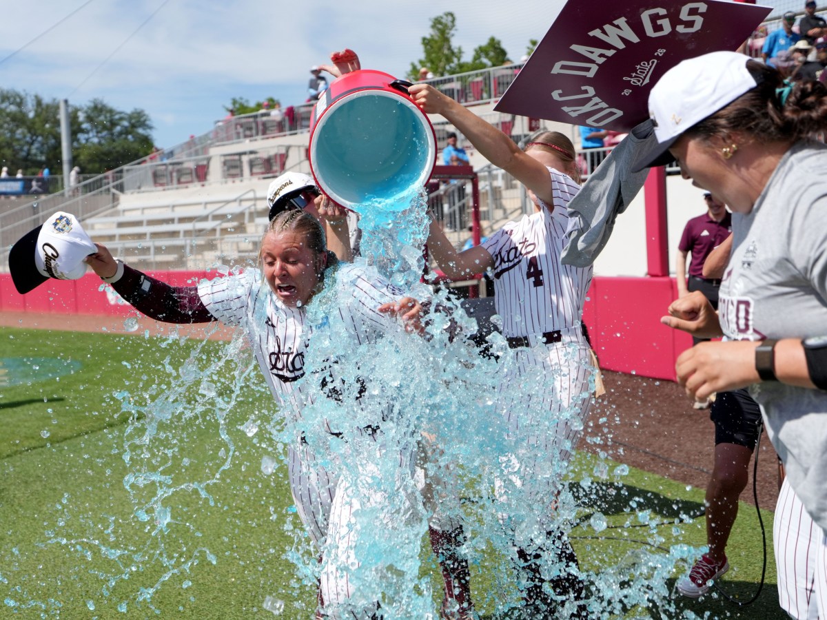 Mississippi State pitcher Delainey Everett has blue Gatorade dumped on her.