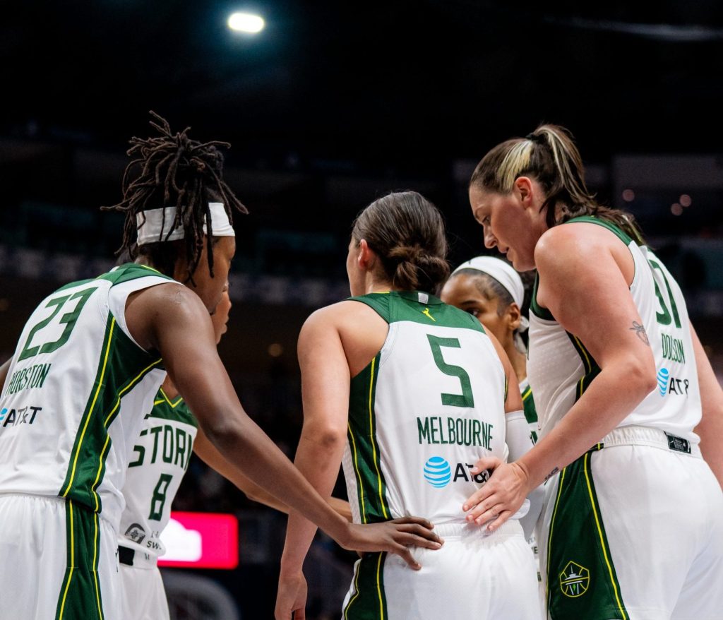 Seattle Storm players, from left, Jordan Horston, Jade Melbourne and Stefanie Dolson huddle together during a game against the Toronto Tempo.