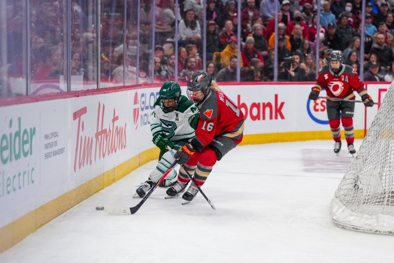 Saulnier (left in white) and Mrázová (right in red) battle over the puck.