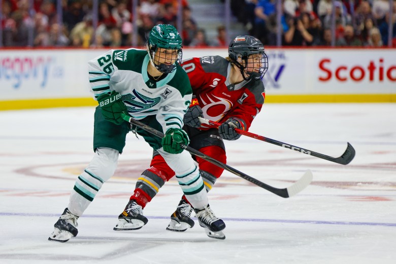 Huber and Vasko battle for positioning. Huber is on the left wearing a white away uniform, while Vasko is on the right in a red home one.