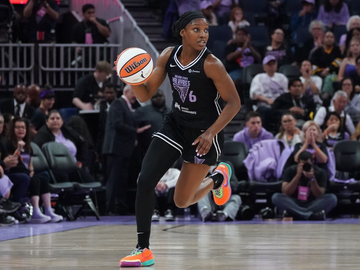 Golden State Valkyries guard-forward Kaila Charles dribbles upcourt against. She is facing the camera with an out of focus crowd behind her.
