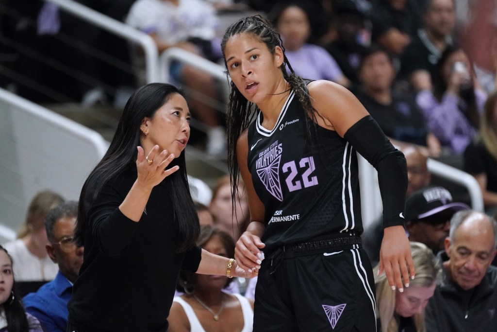 Golden State Valkyries head coach Natalie Nakase talks with guard Veronica Burton. They are both facing the camera with some fans behind them.