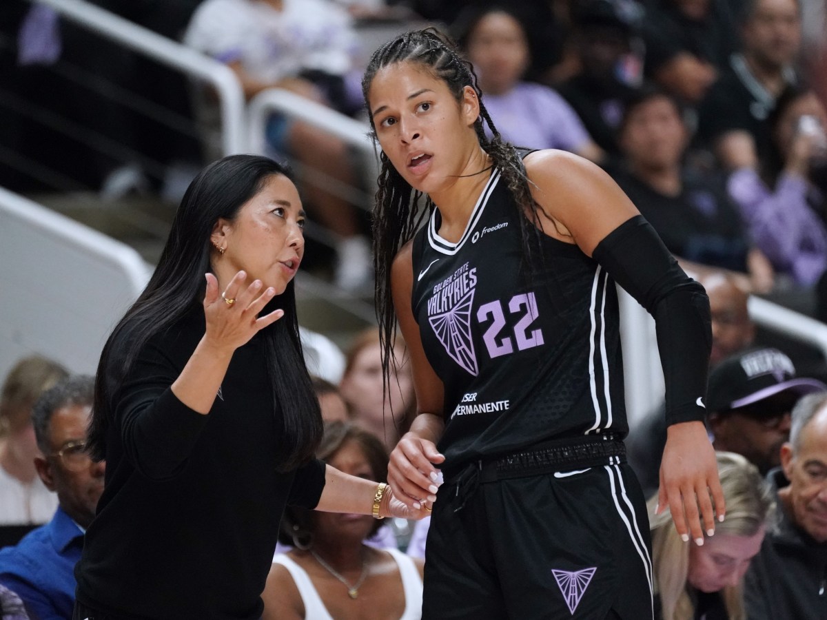 Golden State Valkyries head coach Natalie Nakase talks with guard Veronica Burton. They are both facing the camera with some fans behind them.