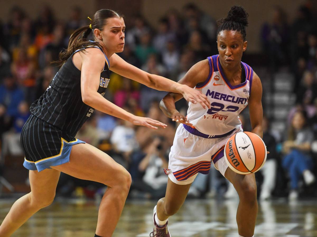 Kiana Williams, wearing a white Phoenix Mercury jersey, dribbles the ball with her left hand. Chicago Sky guard Gabriela Jaquez, wearing a black jersey, tries to stay with her.