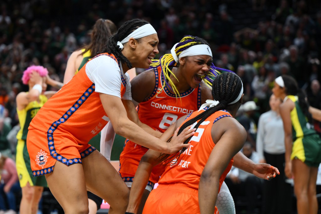 Players in orange uniforms celebrate on the court.