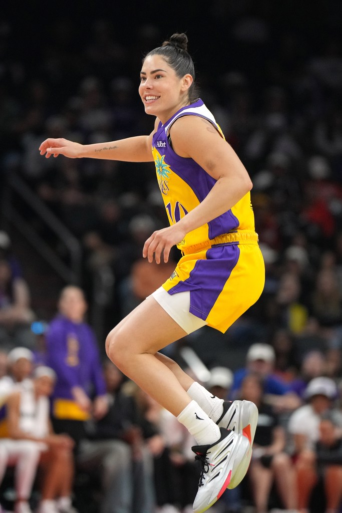 Kelsey Plum jumps in the air with a smile on her face during the Sparks' game against the Phoenix Mercury.