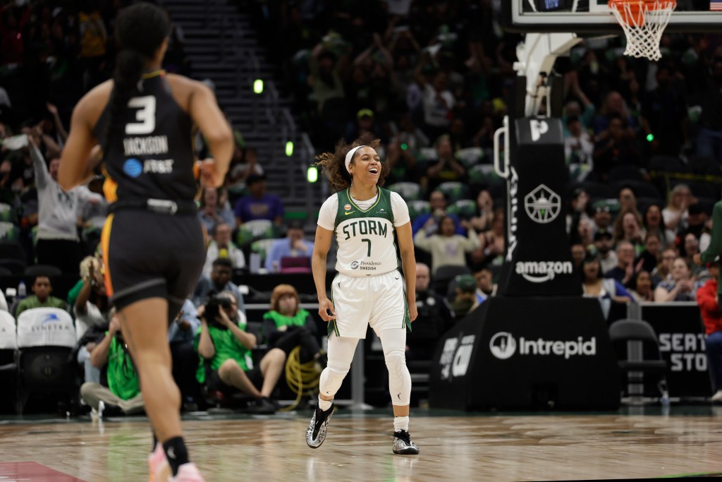 Seattle Storm guard Zia Cooke bobs her head up and down celebrating hitting a shot.
