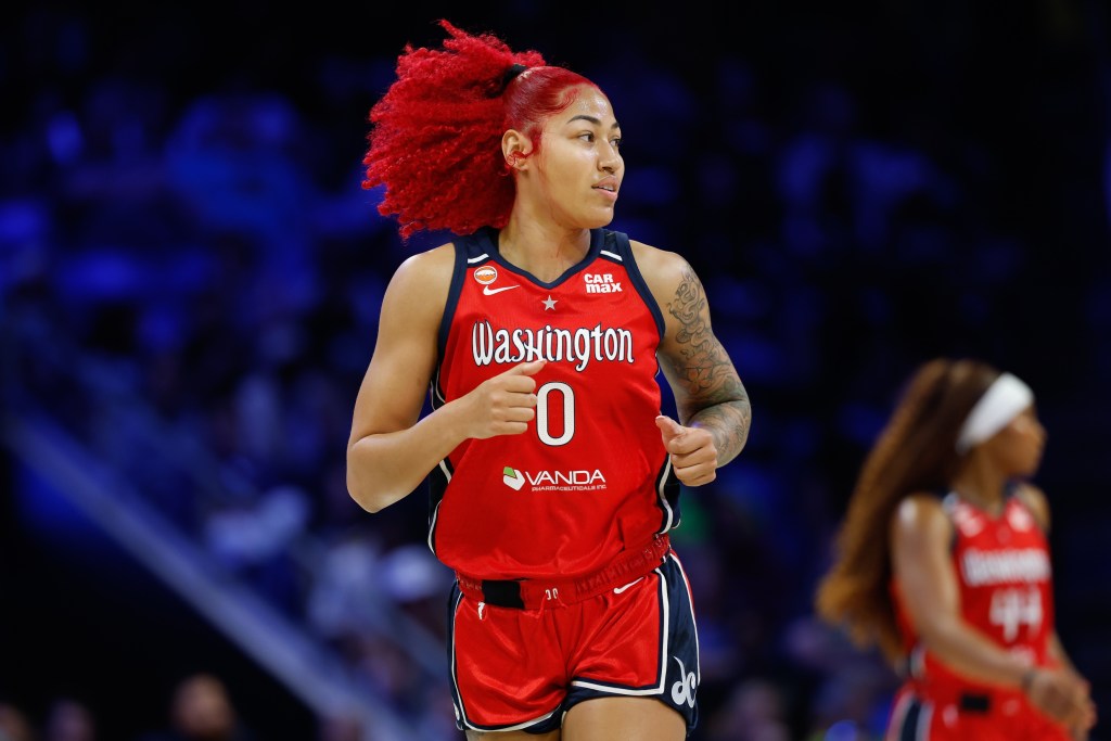 Washington Mystics center Shakira Austin runs down the court, looking off to her left at something out of frame.