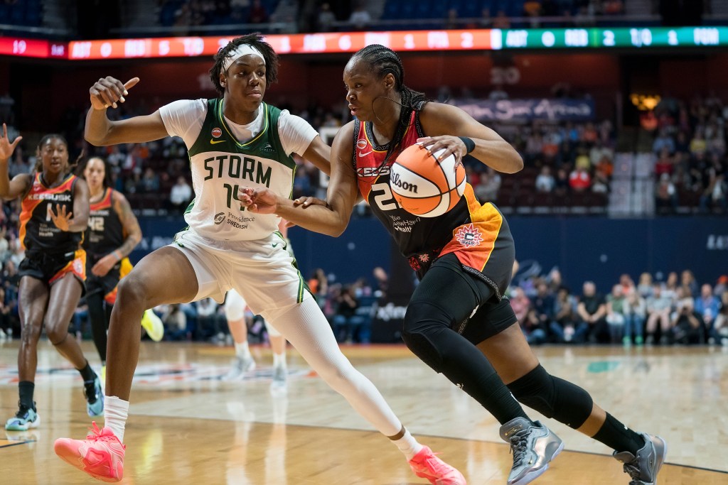 Seattle Storm center Dominique Malonga slides laterally with long legs and arms outstretched against <a rel=