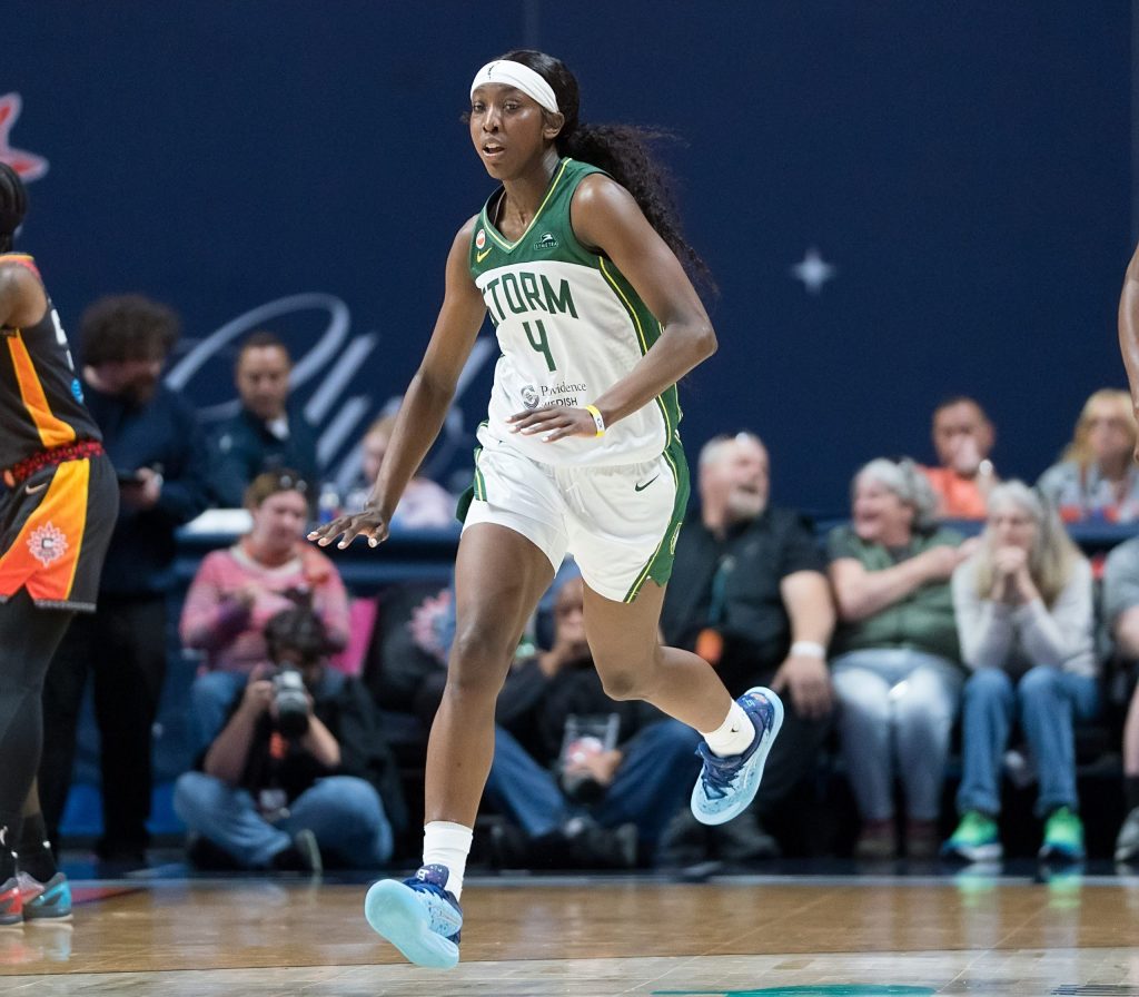 Seattle Storm guard Flau'jae Johnson runs down the court hold her hand out below her hip to indicate that the player she just scored over, <a rel=
