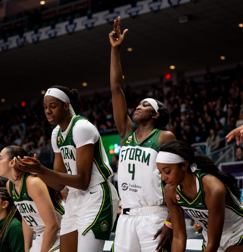 Dominique Malonga claps as she sits down on the left, as <a rel=