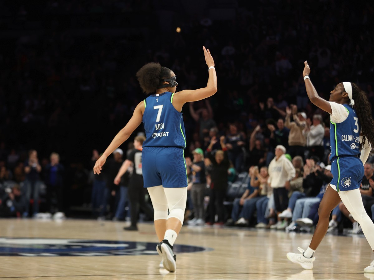Ola Kosu and Maya Caldwell extend their arms to high-five each other in their blue Lynx uniforms.