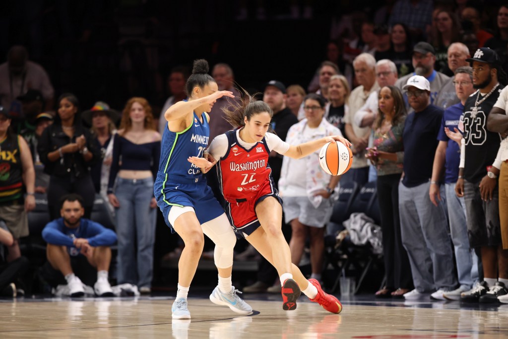 Washington Mystics guard Sonia Citron dribbles the ball with her left hand on the perimeter. She is leaning into her defender and the ball is positioned almost a full arm's length away from her body, making it hard for the defender to reach.