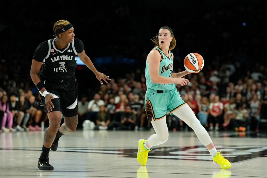 Sabrina Ionescu has her head up and her mouth open wide as she looks to make a pass while <a rel=