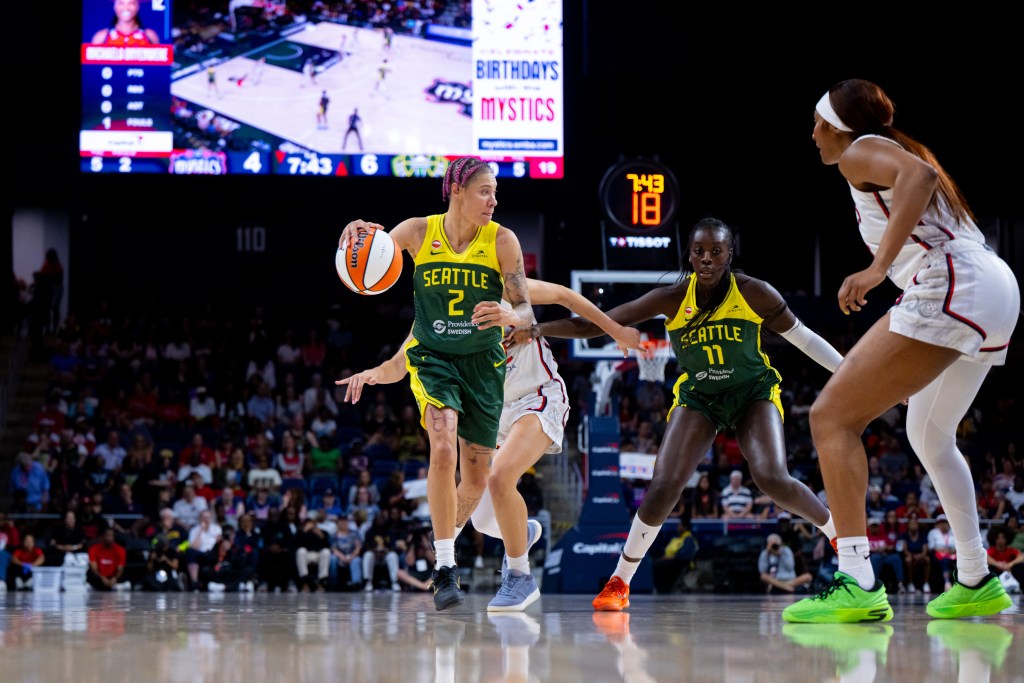 Natisha Hiedeman dribbles toward a Washington Mystics defender, with another Mysstic defender trailing behind her where Awa Fam set a screen and awaits a potential pass back.