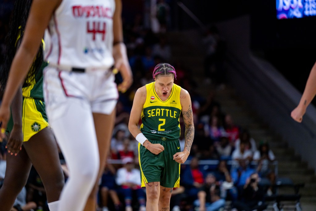 Natisha Hiedeman flexes and balls her fists as she screams toward the floor in celebration.
