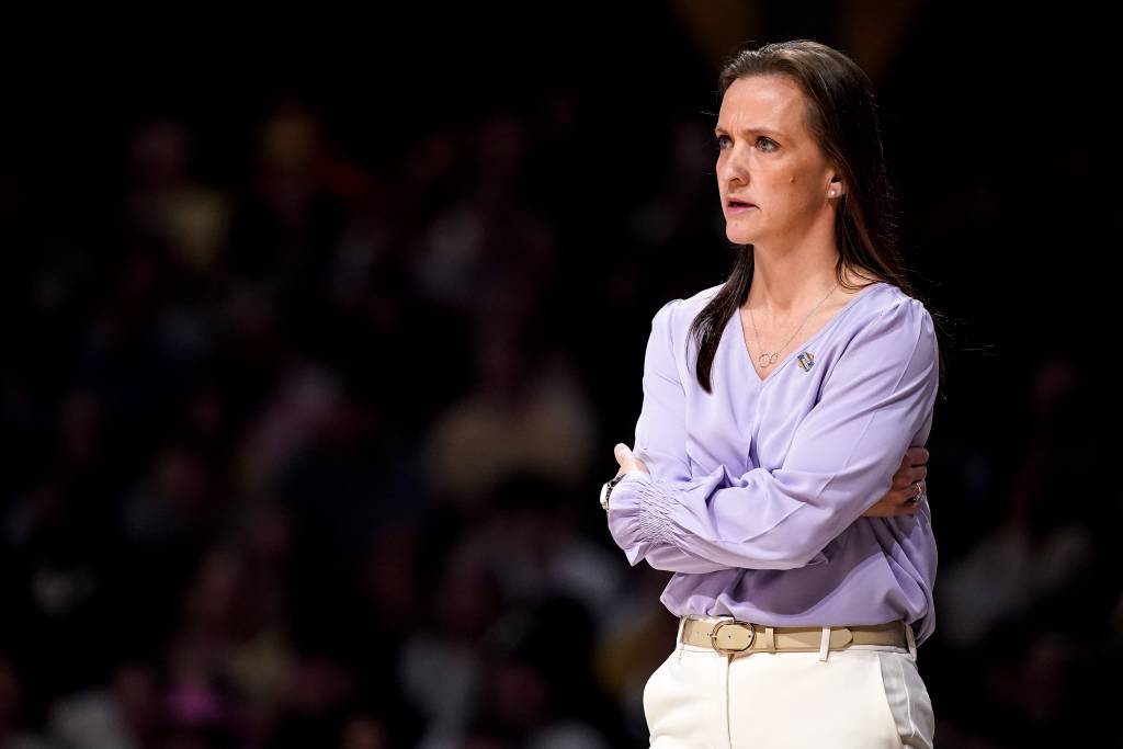 High Point head coach Chelsea Banbury crosses her arms and looks toward the court as her team plays in the first round of the 2026 NCAA Tournament.