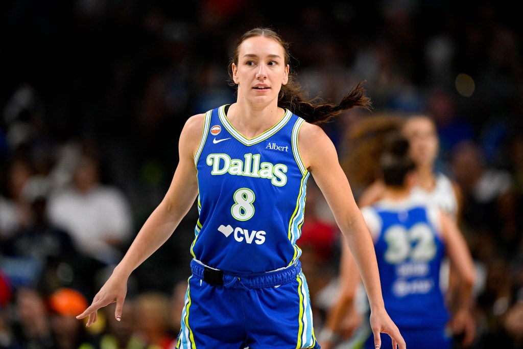 Alanna Smith in a blue Dallas jersey, with focused expression, runs on the court during a WNBA game.