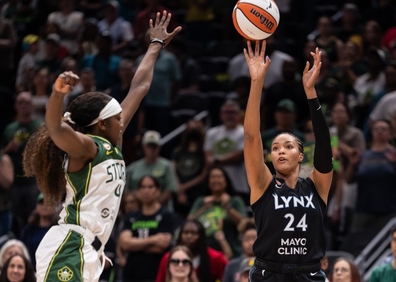 Napheesa Collier releases an orange and white basketball as Flau'Jae Johnson flies into the frame
