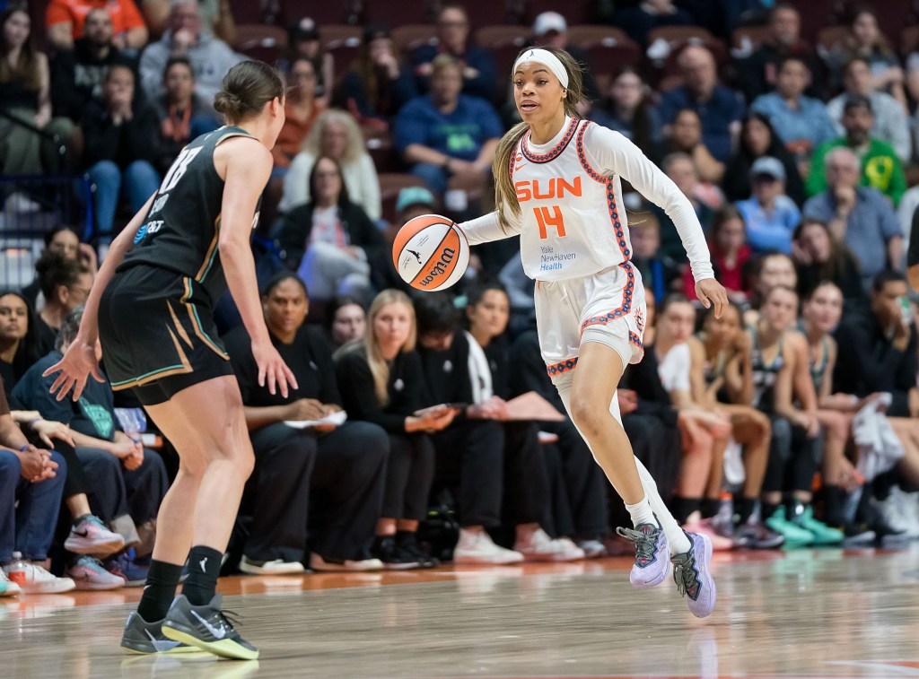 Connecticut Sun guard Harmoni Turner dribbles the ball with her right hand. A New York Liberty defender is right in front of her, and she has her eyes up, looking straight ahead.