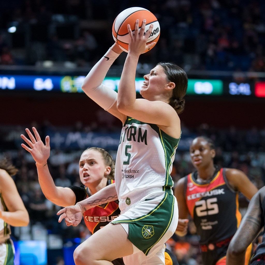 Jade Melbourne floats with both hands on the ball, arms poised for the shot.
