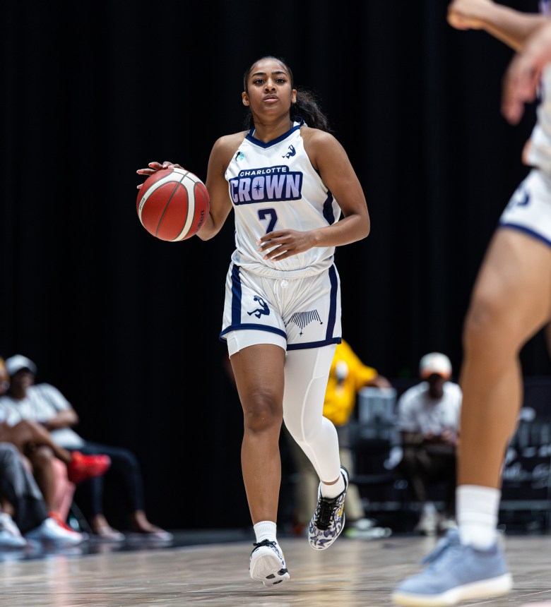 Deja Kelly, wearing a white sleeve, dribbles the ball up the floor during a game for the Crown.
