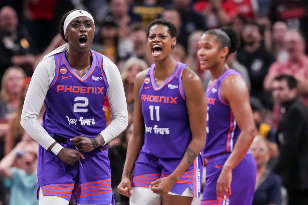 Three Phoenix Mercury basketball players in purple jerseys celebrate energetically on the court.