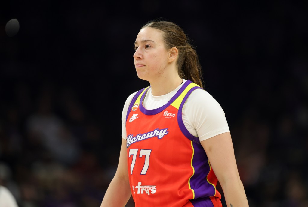 Marta Suarez in a red and purple Mercury jersey with number 77, looking focused on the court.