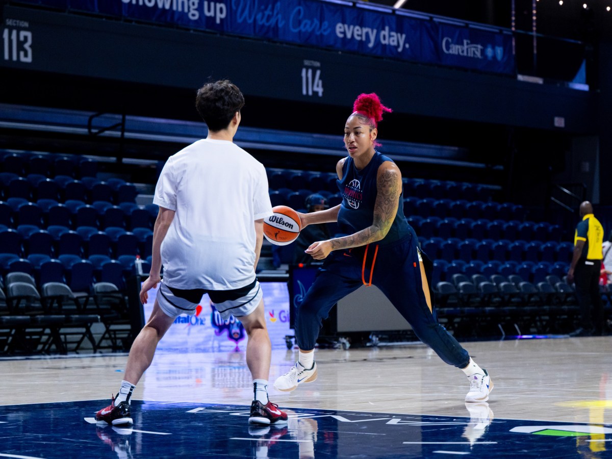 Washington Mystics center Shakira Austin dribbles the ball near the free throw line as a Mystics practice player defends her.