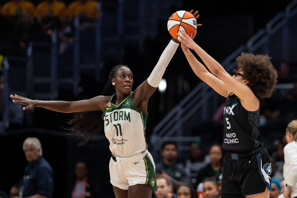 Awa Fam stretches out to palm the ball with her left hand as Olivia Miles tries to release the ball at the top of her shot.