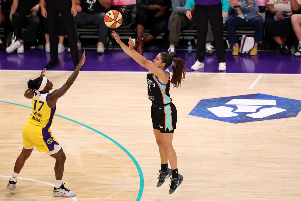 New York Liberty guard Marine Fauthoux jumps into a three point basket over the contest of Los Angeles Sparks guard