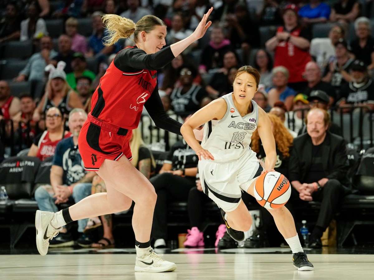 Las Vegas Aces guard Mai Yamamoto dribbles the ball with her left hand as Portland Fire center Luisa Geiselsoder tries to stay on her right hip.