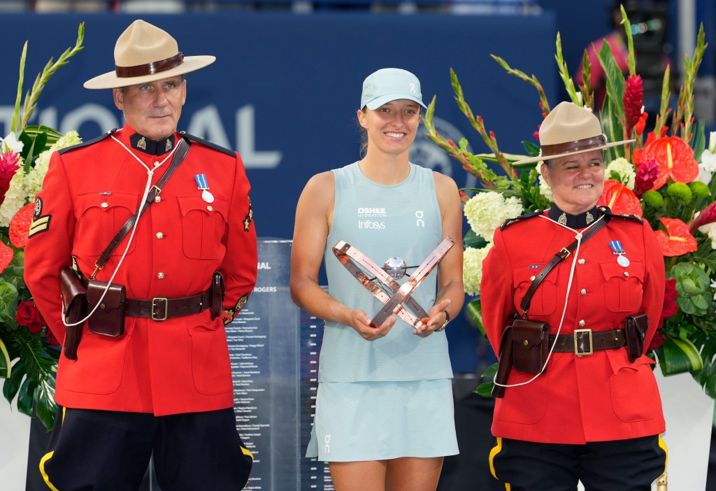 Iga Swiatek poses with the winner's trophy at the National Bank Open
