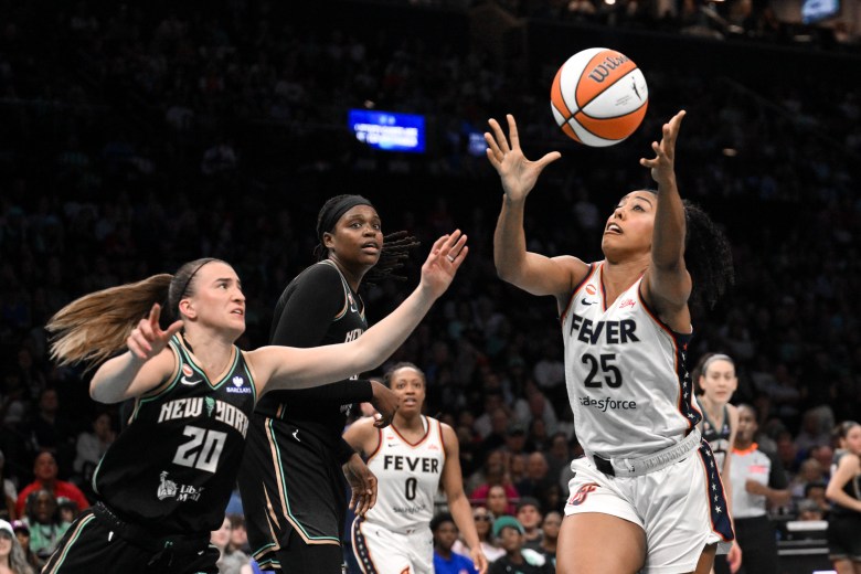 Sabrina Ionescu and Jonquel Jones are trying to reach for possession of the ball while trying to defend Monique Billings, the Fever player that was going to have possession.