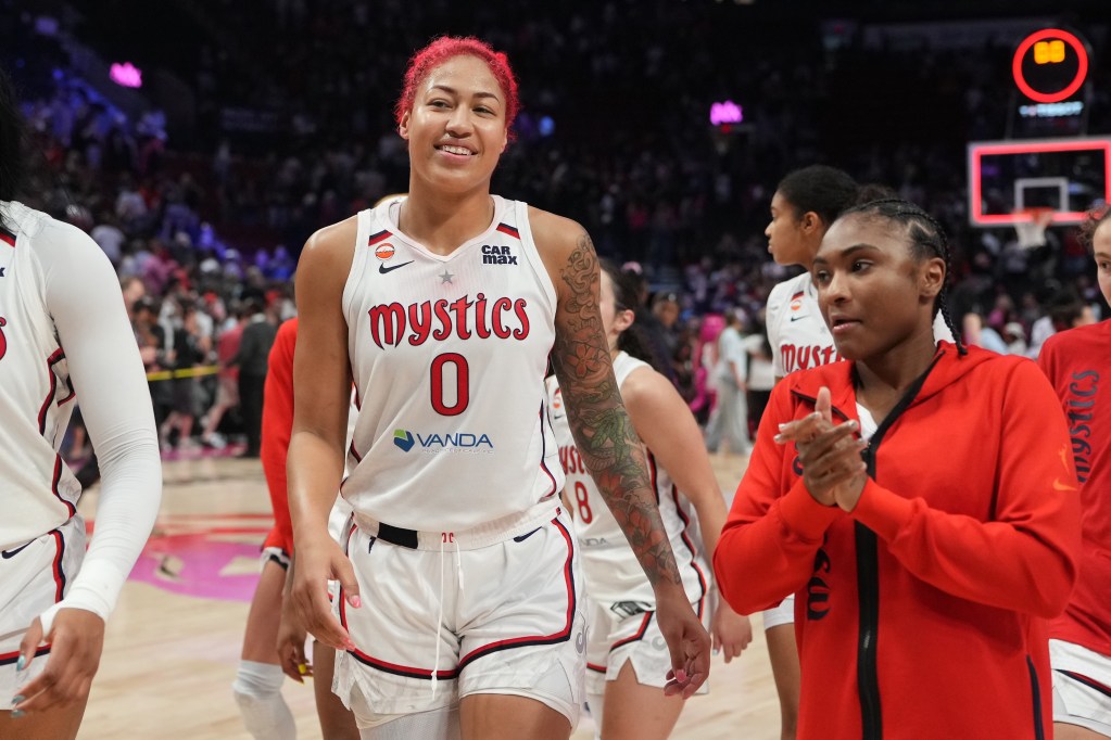 Washington Mystics center Shakira Austin and guard Rori Harmon walk off the court after a game. Austin smiles, and Harmon claps her hands together.