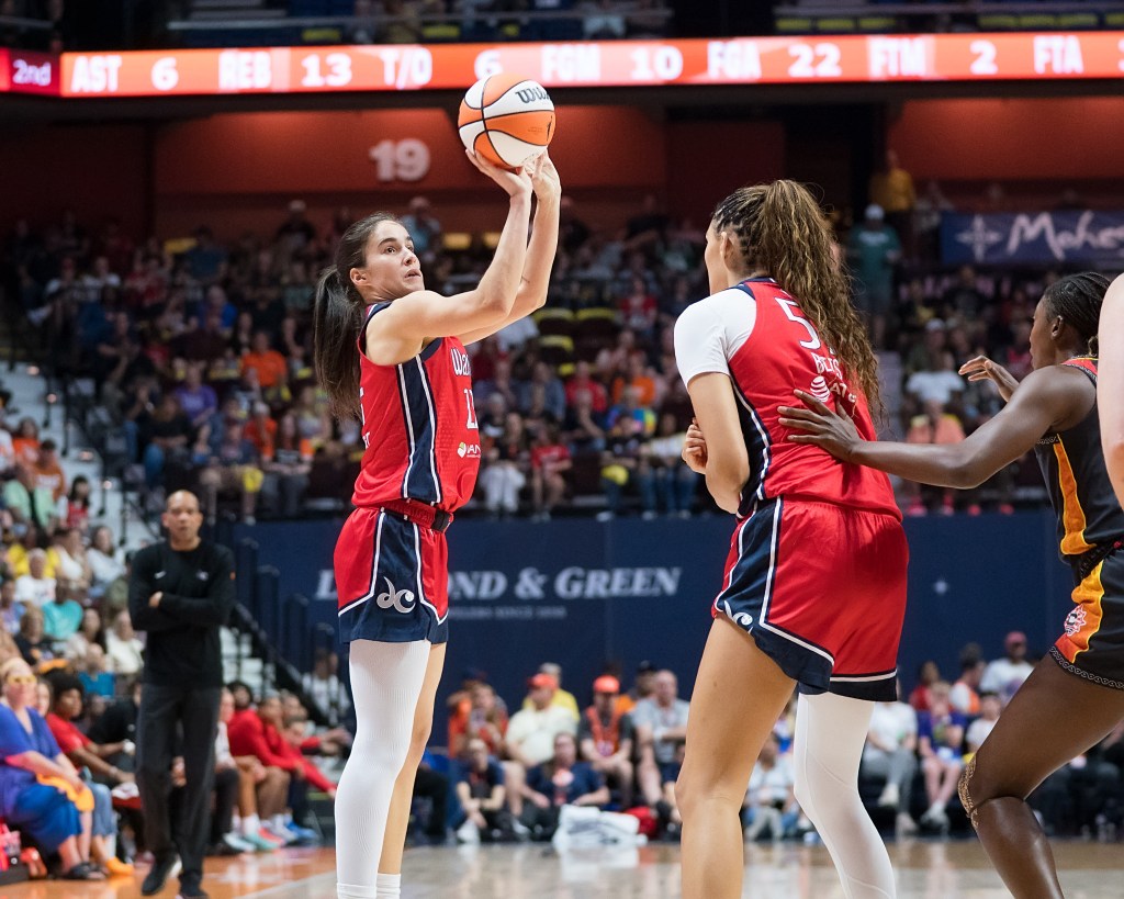 Washington Mystics guard Sonia Citron shoots an open right-handed jump shot. Center Lauren Betts is standing right in front of her, which prevents a defender from contesting the shot.