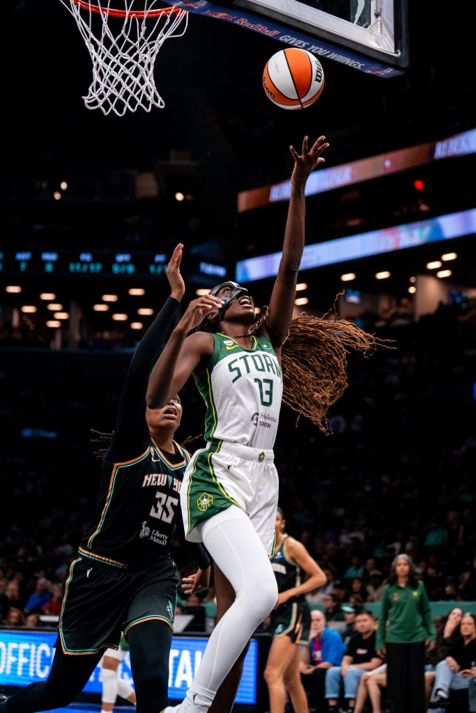 Ezi Magbegor goes up for a statue of liberty layup with the ball in her left hand as <a rel=