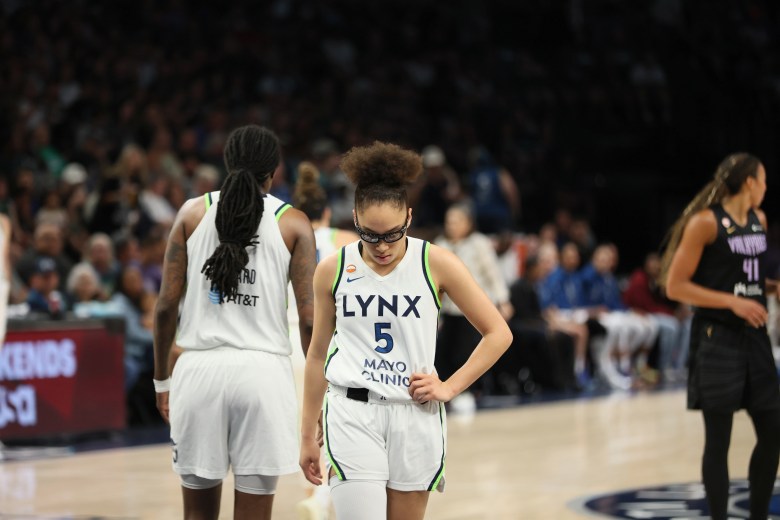 Olivia Miles puts a hand on her hip and looks towards the ground on a basketball court.