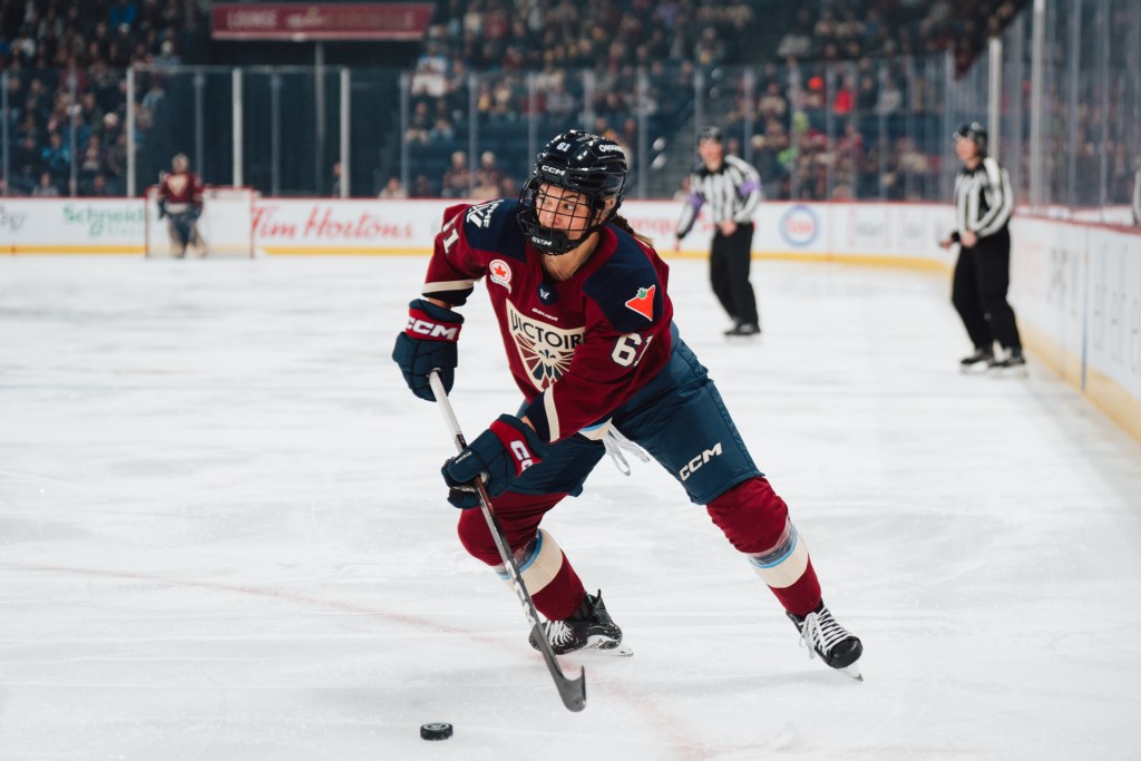 A women's ice hockey player handles the puck.