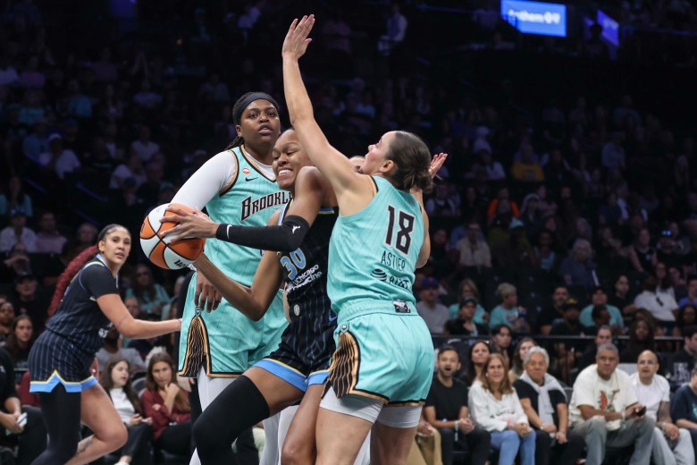 Jonquel Jones and Pauline Astier look to defend Azura Stevens near the basket.