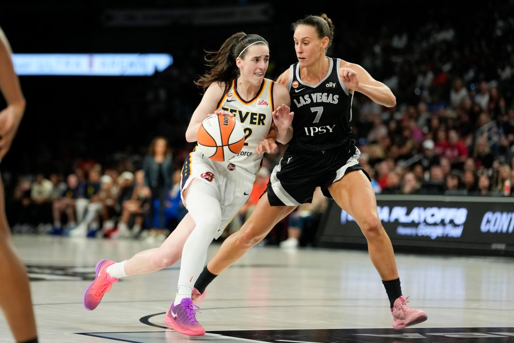 Indiana Fever guard Caitlin Clark dribbles the ball while being defended by Las Vegas Aces forward Stephanie Talbot