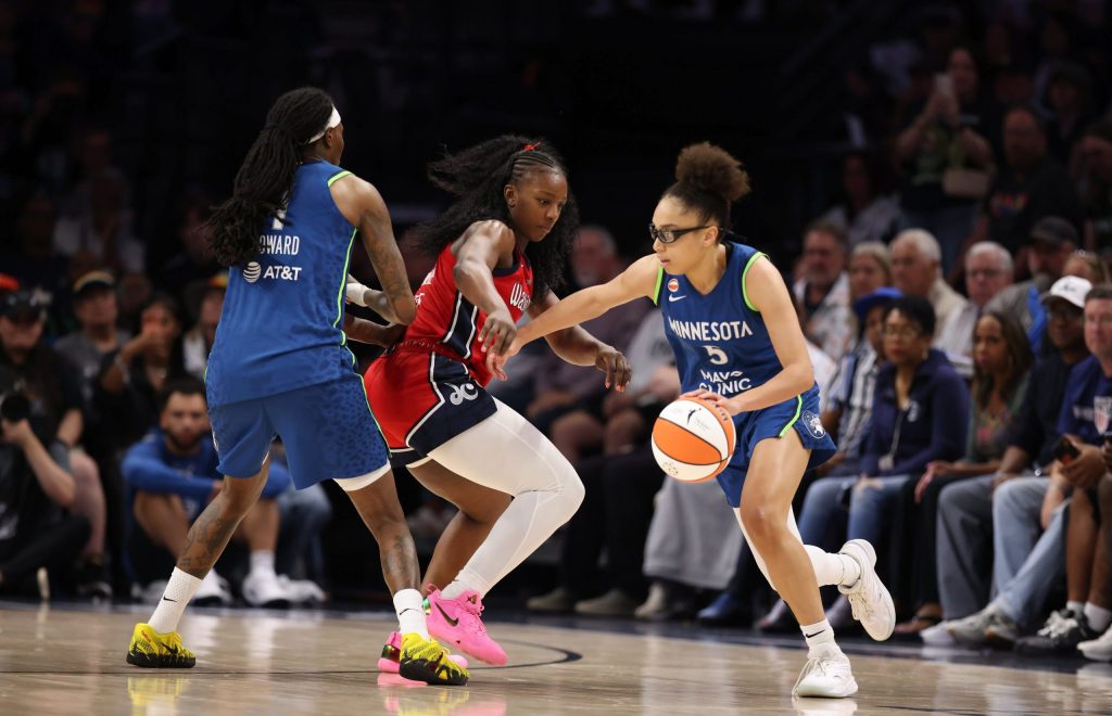 Minnesota Lynx guard Olivia Miles dribbles with her left hand and gets a screen from forward Natasha Howard. Washington Mystics forward Michaela Onyenwere, moving to her right, tries to get over the screen to stay with Miles.