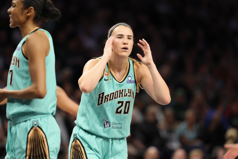 Sabrina Ionescu looks surprised with her hands near her head