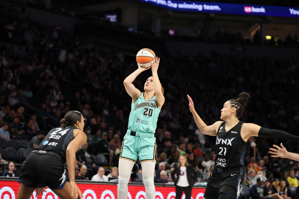 Sabrina Ionescu shoots the ball while Kayla McBride guards her